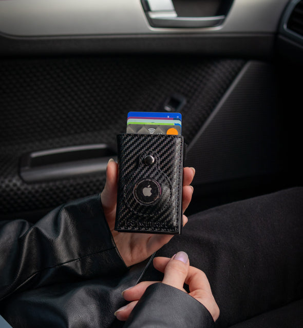 Kompact Carbon Trace in hands with Air Tag and cards showing